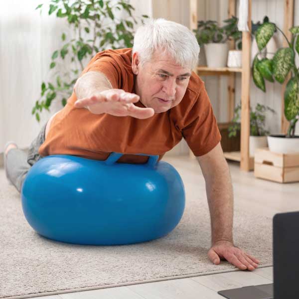 An Older Man Doing Exercises On A Blue Exercise Ball.